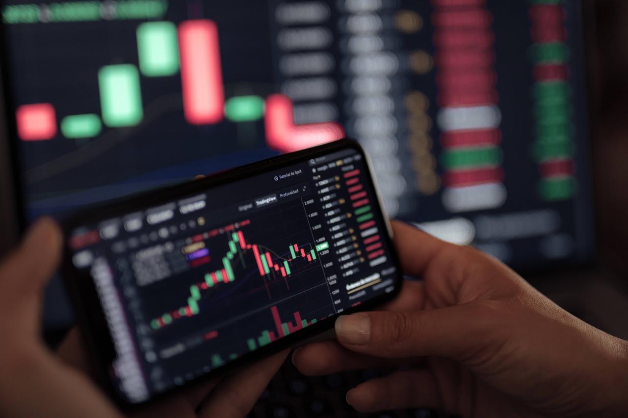 Blick auf ein Smartphone-Display, auf dem ein Diagramm die Kursentwicklung eines Finanzprodukts anzeigt. Blick auf ein Smartphone-Display, auf dem ein Diagramm die Kursentwicklung eines Finanzprodukts anzeigt.
