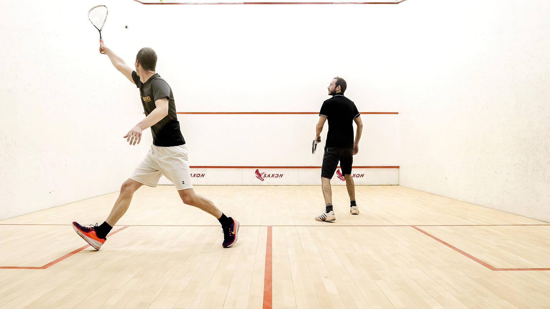 Zwei Squash-Spieler in einer Halle 