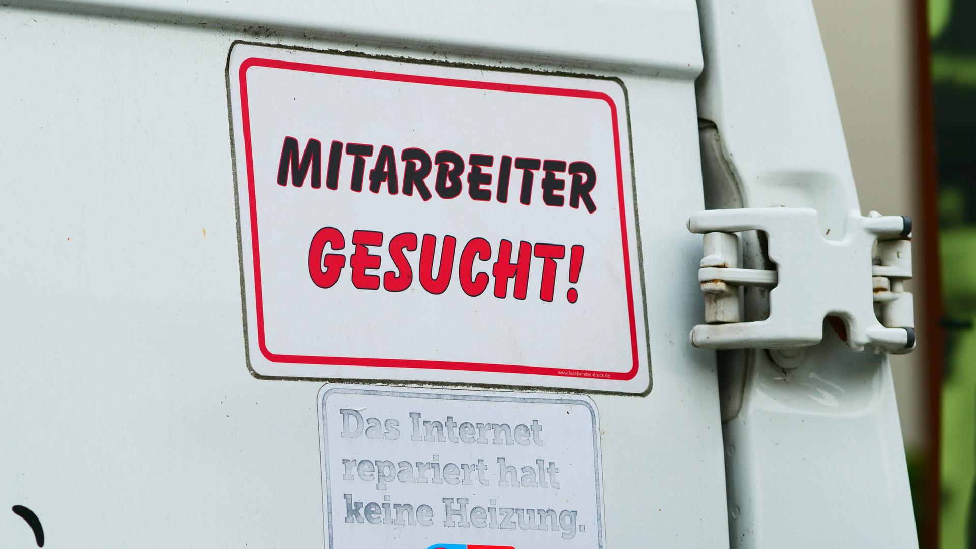 "Mitarbeiter gesucht!" steht auf einem Schild am Transporter eines Handwerksbetriebs für Heizung und Sanitär. "Mitarbeiter gesucht!" steht auf einem Schild am Transporter eines Handwerksbetriebs für Heizung und Sanitär.
