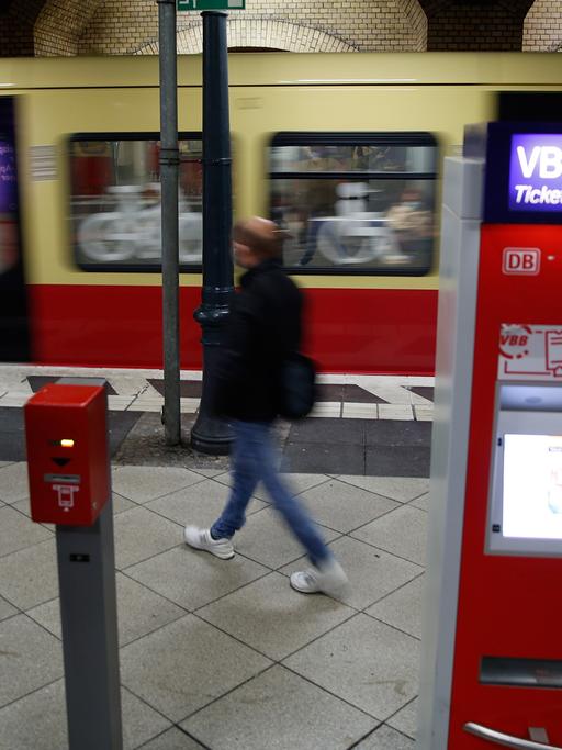 Fahrgäste laufen an einem Fahrkartenautomaten auf dem Bahnsteig der Ringbahn der Berliner S-Bahn vorbei.