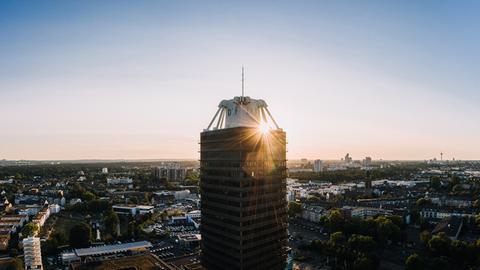 Das Hochhaus des Deutschlandfunks in einer Luftaufnahme mit untergehender Sonne im Hintergrund.