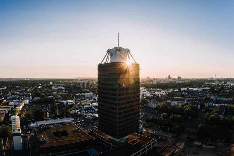 Das Hochhaus des Deutschlandfunks in einer Luftaufnahme mit untergehender Sonne im Hintergrund. Das Hochhaus des Deutschlandfunks in einer Luftaufnahme mit untergehender Sonne im Hintergrund.
