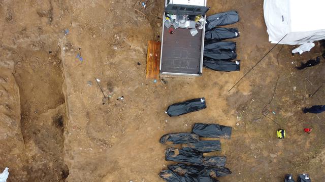 Schwarze Leichensäcke liegen neben einem Transporter im ukrainischen Ort Butscha, wo Leichen aus einem Massengrab geborgen wurden.
