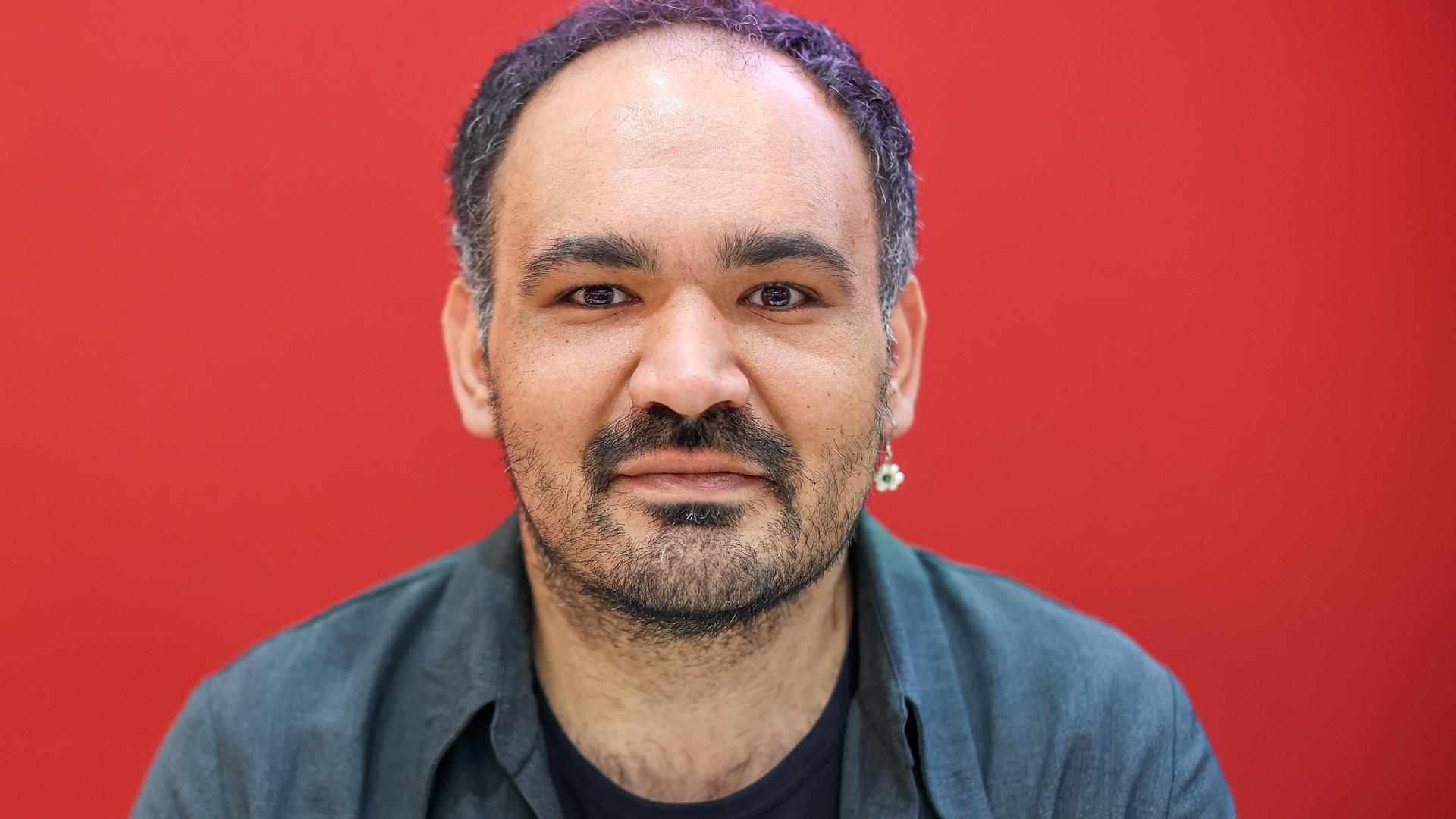 Dinçer Güçyeter, ein mittelalter Mann mit Dreitagebart und im graublauen Hemd, schaut direkt in die Kamera. Dinçer Güçyeter, ein mittelalter Mann mit Dreitagebart und im graublauen Hemd, schaut direkt in die Kamera.