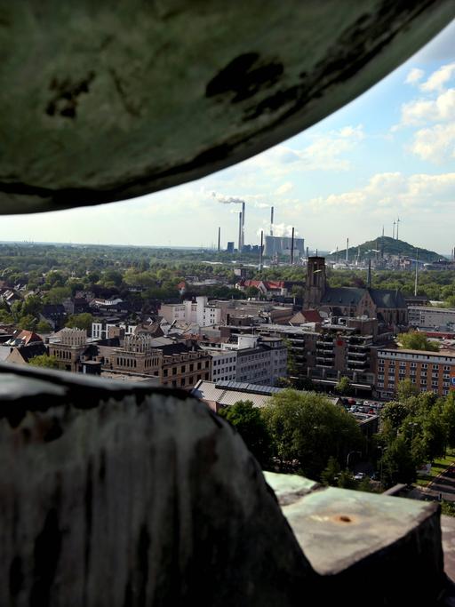 Blick von einem Dach aus auf den Stadtteil Gelsenkirchen-Buer mit den Schloten eines Kraftwerks im Bildhintergrund.