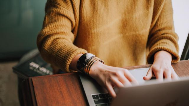 Frau schreibt am Laptop