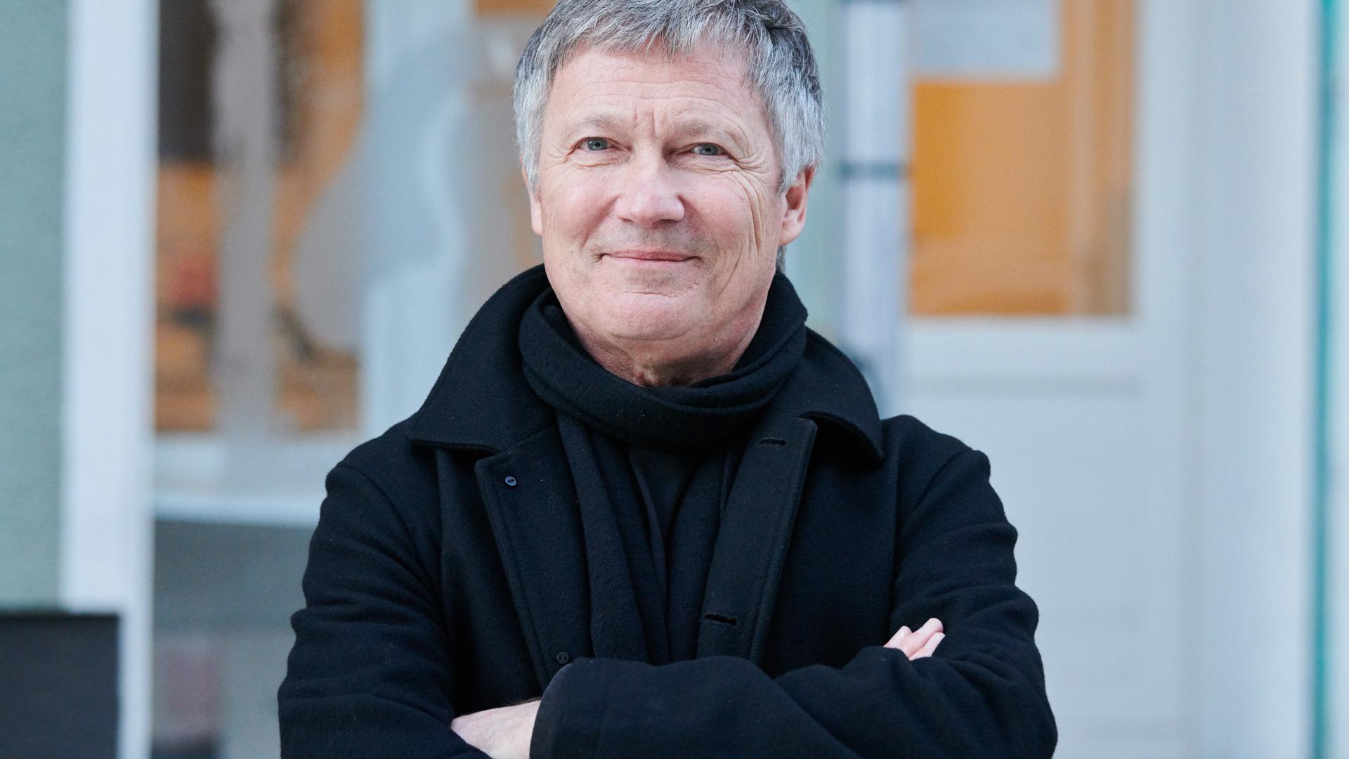 Michael Rother steht freundlich lächelnd und mit verschränkten Armen vor der Kamera Michael Rother steht freundlich lächelnd und mit verschränkten Armen vor der Kamera