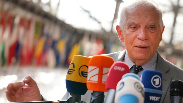 Der EU-Außenbeauftragte Borrell steht vor Mikrofonen. Im Hintergrund verschwommen die Fahnen der EU-Mitglieder.