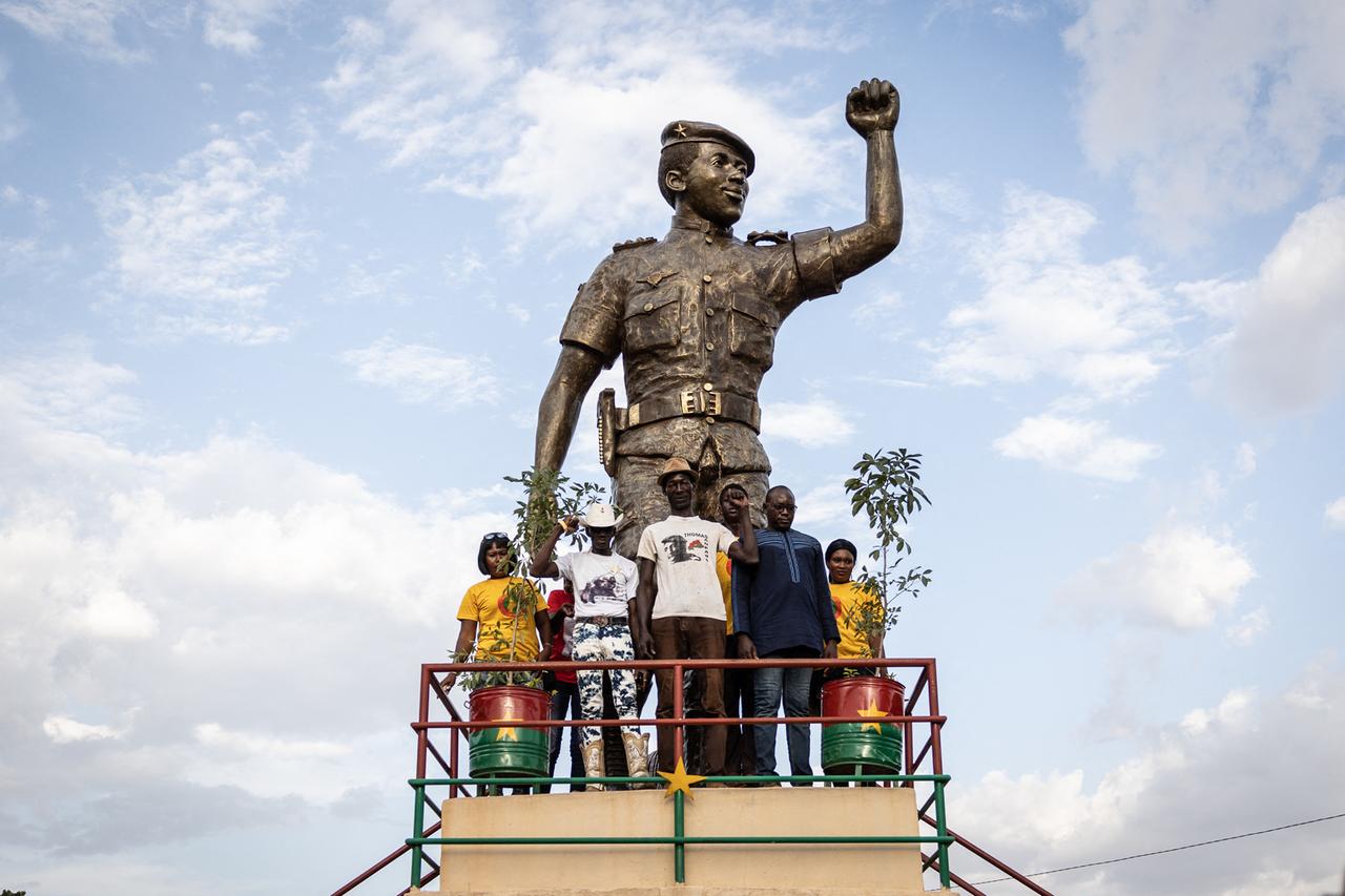 Menschen posieren für ein Foto neben der Statue von Thomas Sankara während der Zeremonie zum 34. Jahrestag. Menschen posieren für ein Foto neben der Statue von Thomas Sankara während der Zeremonie zum 34. Jahrestag.