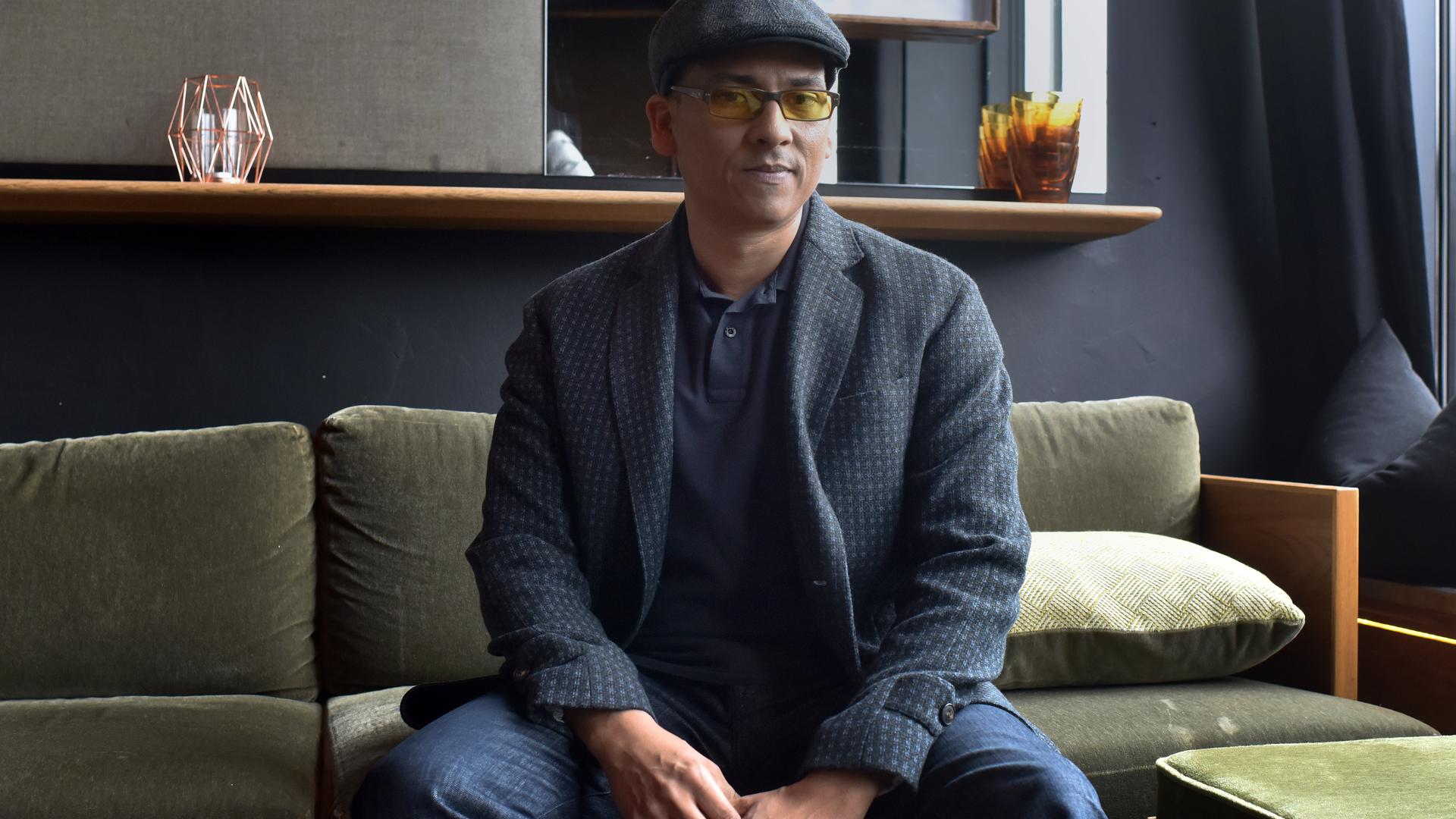 Der Sänger Xavier Naidoo sitzt auf einem Sofa und blickt in die Kamera. Er trägt eine Mütze und eine Brille mit getönten Gläsern. Der Sänger Xavier Naidoo sitzt auf einem Sofa und blickt in die Kamera. Er trägt eine Mütze und eine Brille mit getönten Gläsern.