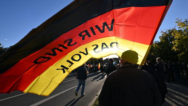 "Wir sind das Volk" steht auf der Fahne, die ein Teilnehmer auf einer Kundgebung der Thüringer AfD unter dem Motto "Zuerst unser Land! Leben muss bezahlbar sein" trägt.