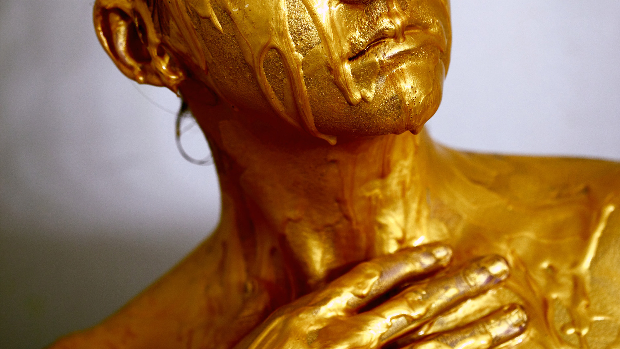 Auszug eines Gesichts mit goldener Farbe bemalt. 