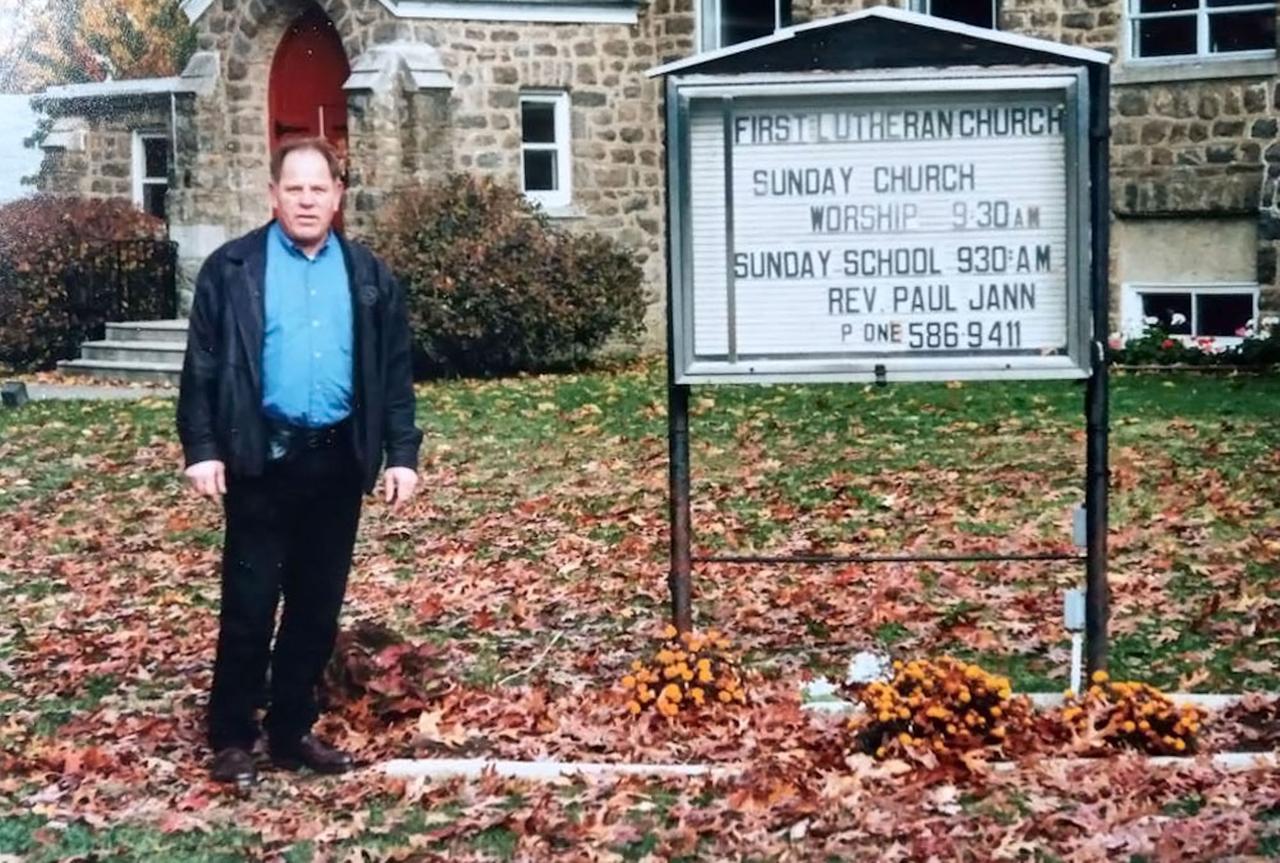 Michael Hanser steht als erwachsener Mann vor einer Kirche in Pennsylvania. Michael Hanser steht als erwachsener Mann vor einer Kirche in Pennsylvania.