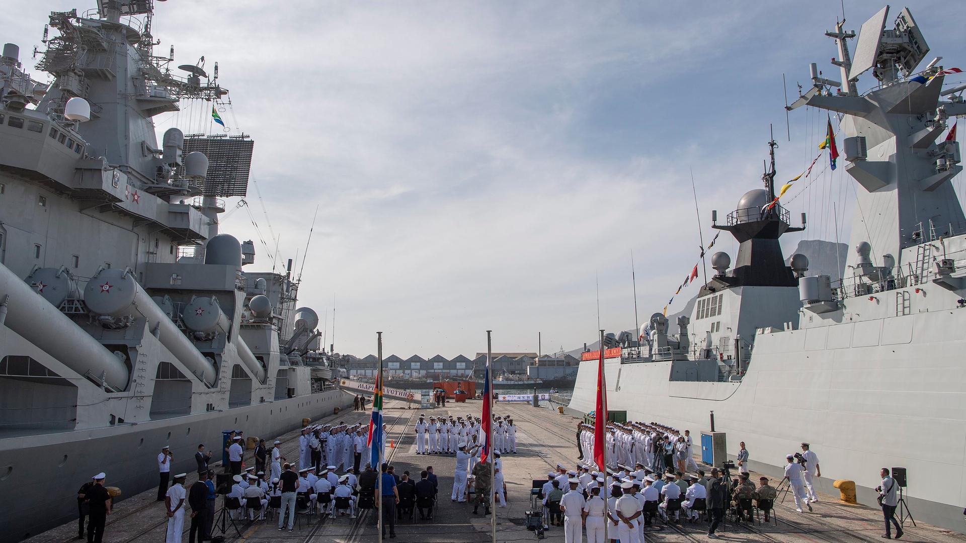 Eröffnung des ersten gemeinsamen Marinemanövers von Südafrika, China und Russland im November 2019 in Kapstadt: zwei Kriegsschiffe, zahlreiche Marinesoldaten und die drei Landesflaggen sind zu sehen. Eröffnung des ersten gemeinsamen Marinemanövers von Südafrika, China und Russland im November 2019 in Kapstadt: zwei Kriegsschiffe, zahlreiche Marinesoldaten und die drei Landesflaggen sind zu sehen.
