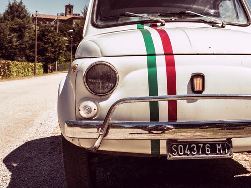 Ein Original Fiat 500 in weiß mit den Farben der italienischen Flagge auf der Kühlerhaube.