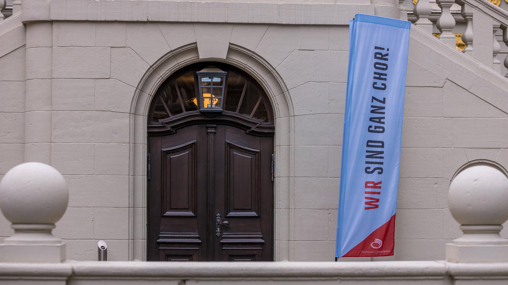 Ein Banner an der Alten Börse trägt den Schriftzug "Wir sind ganz Chor".