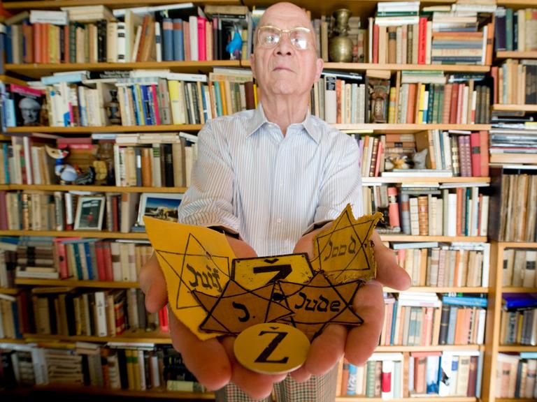 Der Holocaust-Überlebende Wolfgang Haney zeigt Judensterne aus seiner Sammlung von Objekten antisemitischer Propaganda.