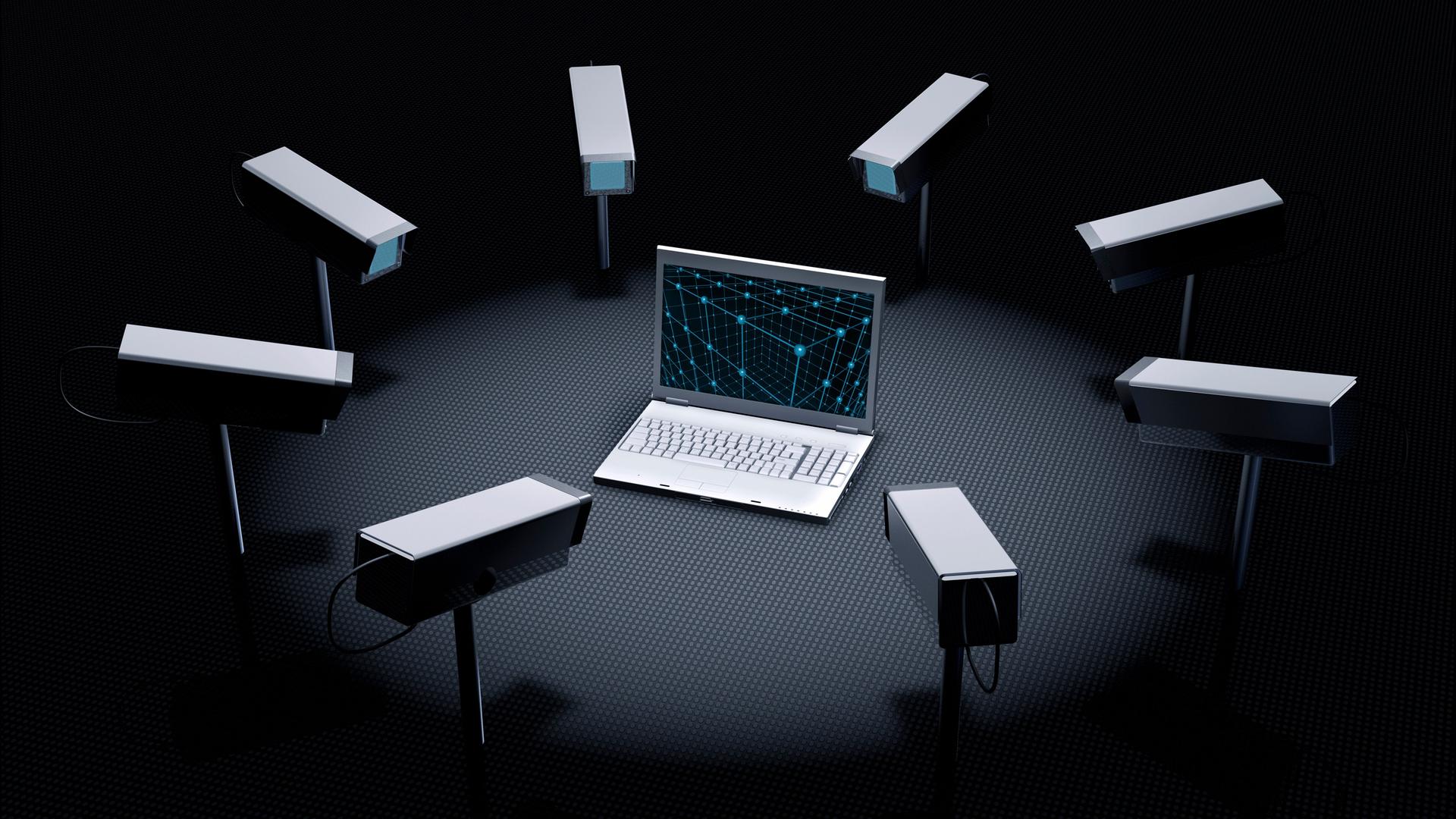 Illustration: Überwachungskameras stehen im Kreis und zeigen alle auf ein Laptop in der Mitte. Illustration: Überwachungskameras stehen im Kreis und zeigen alle auf ein Laptop in der Mitte.