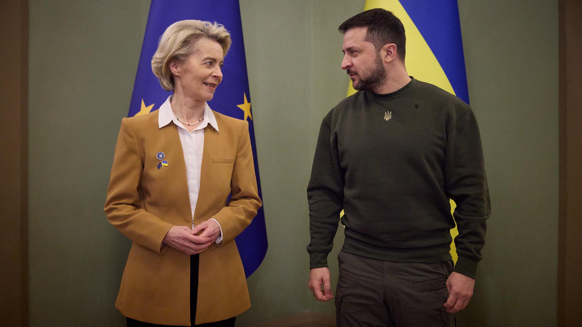 EU-Kommissionspräsidentin Ursula von der Leyen und der ukrainische Präsident Wolodymyr Selenskyj stehen nebeneinander und schauen sich an. EU-Kommissionspräsidentin Ursula von der Leyen und der ukrainische Präsident Wolodymyr Selenskyj stehen nebeneinander und schauen sich an.