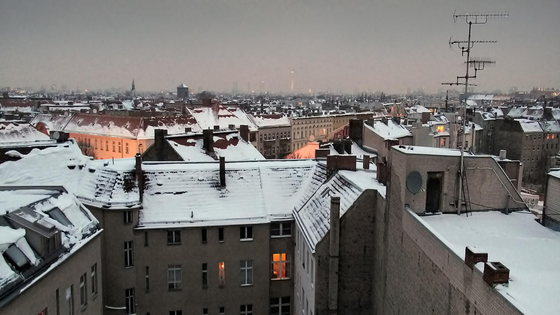 Die Dächer von Berlin im Winter, mit Schnee bedeckt und erleuchteten Fenstern. Die Dächer von Berlin im Winter, mit Schnee bedeckt und erleuchteten Fenstern.