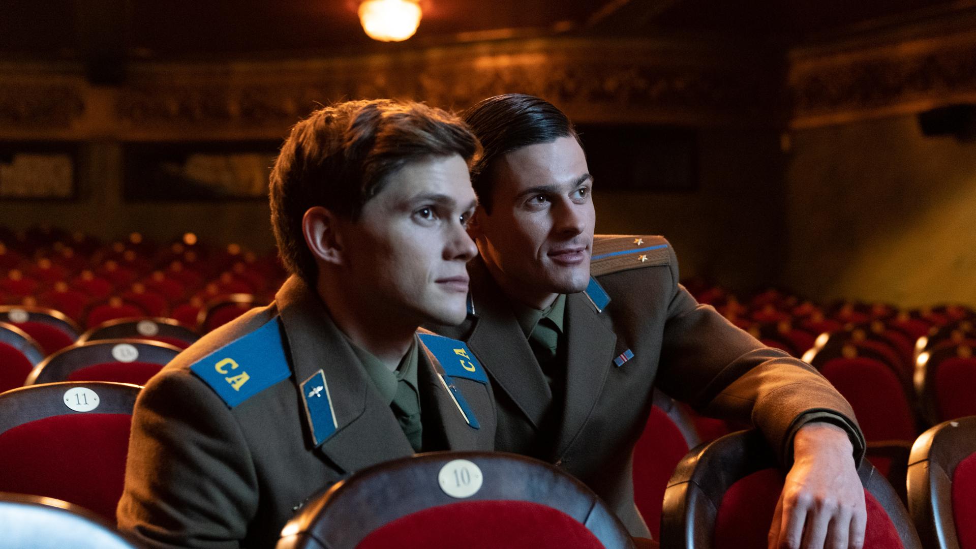 Zwei junge Soldaten in Uniformen der Roten Armee sitzen allein in einem Kinosaal. Zwei junge Soldaten in Uniformen der Roten Armee sitzen allein in einem Kinosaal.