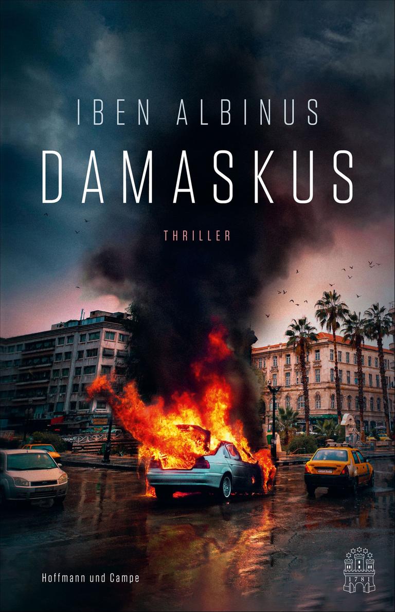 Das Cover des Krimis von Iben Albinus, "Damaskus". Es zeigt eine Straßenszene, auf der Kreuzung steht ein brennendes Auto. Das Cover des Krimis von Iben Albinus, "Damaskus". Es zeigt eine Straßenszene, auf der Kreuzung steht ein brennendes Auto.