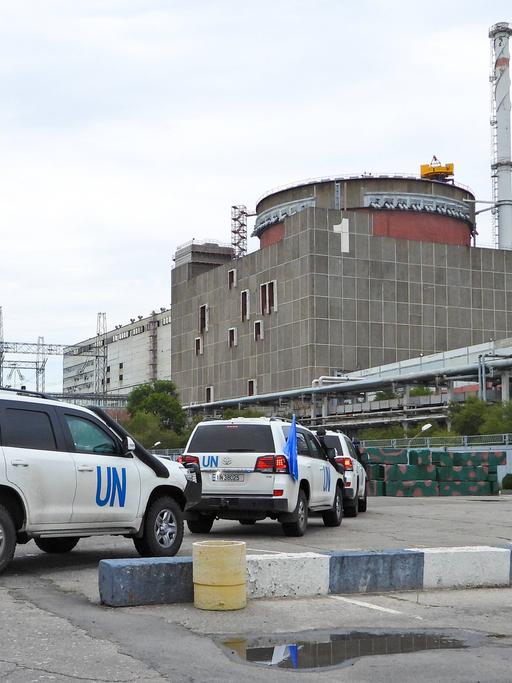 Mehere UN-Autos stehen vor dem Gelände des ukrainischen Atomkraftwerks.