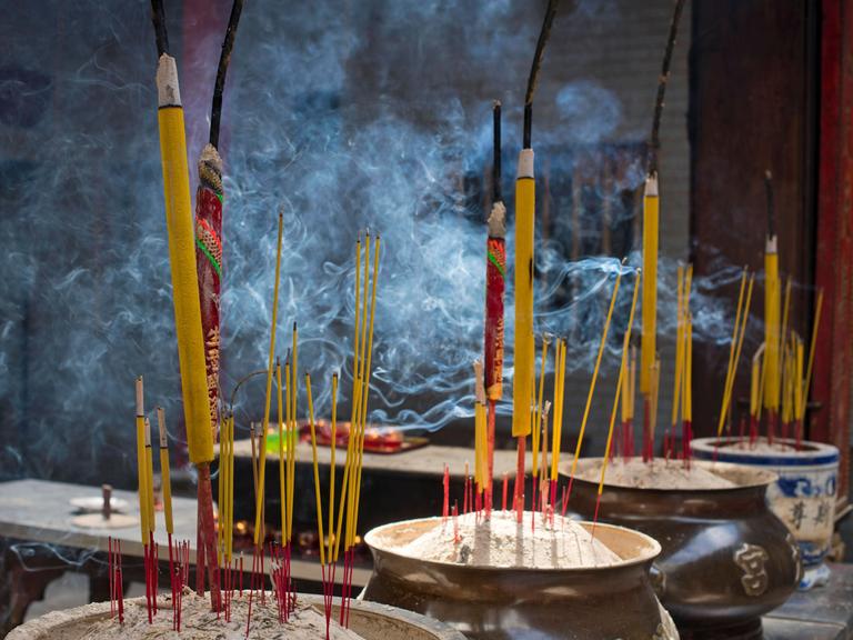 Brennende Räucherstäbchen in einem Topf aus Respekt für Buddha in einem Tempel in Saigon, 2022.