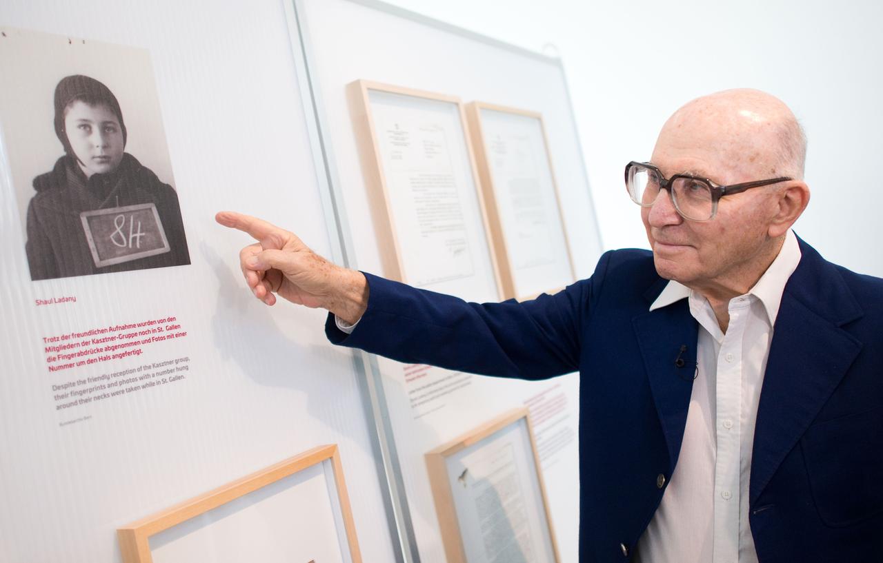 Der Holocaust-Überlebende und israelische Sportler Shaul Ladany steht in der Gedenkstätte des Konzentrationslagers Bergen-Belsen und zeigt auf ein Kinderfoto von ihm. Der Holocaust-Überlebende und israelische Sportler Shaul Ladany steht in der Gedenkstätte des Konzentrationslagers Bergen-Belsen und zeigt auf ein Kinderfoto von ihm.