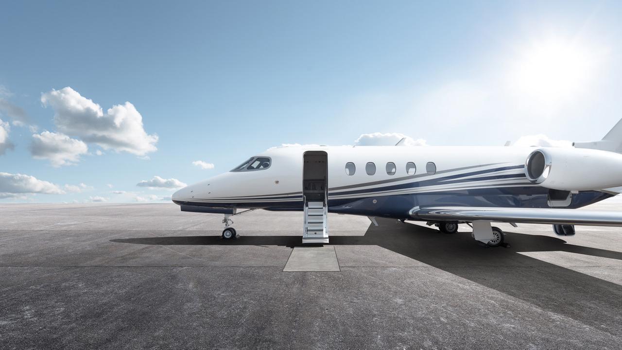 Ein Privatjet steht auf einem Rollfeld mit geöffneter Tür und Teppich vor der Treppe zum einsteigen. Ein Privatjet steht auf einem Rollfeld mit geöffneter Tür und Teppich vor der Treppe zum einsteigen.