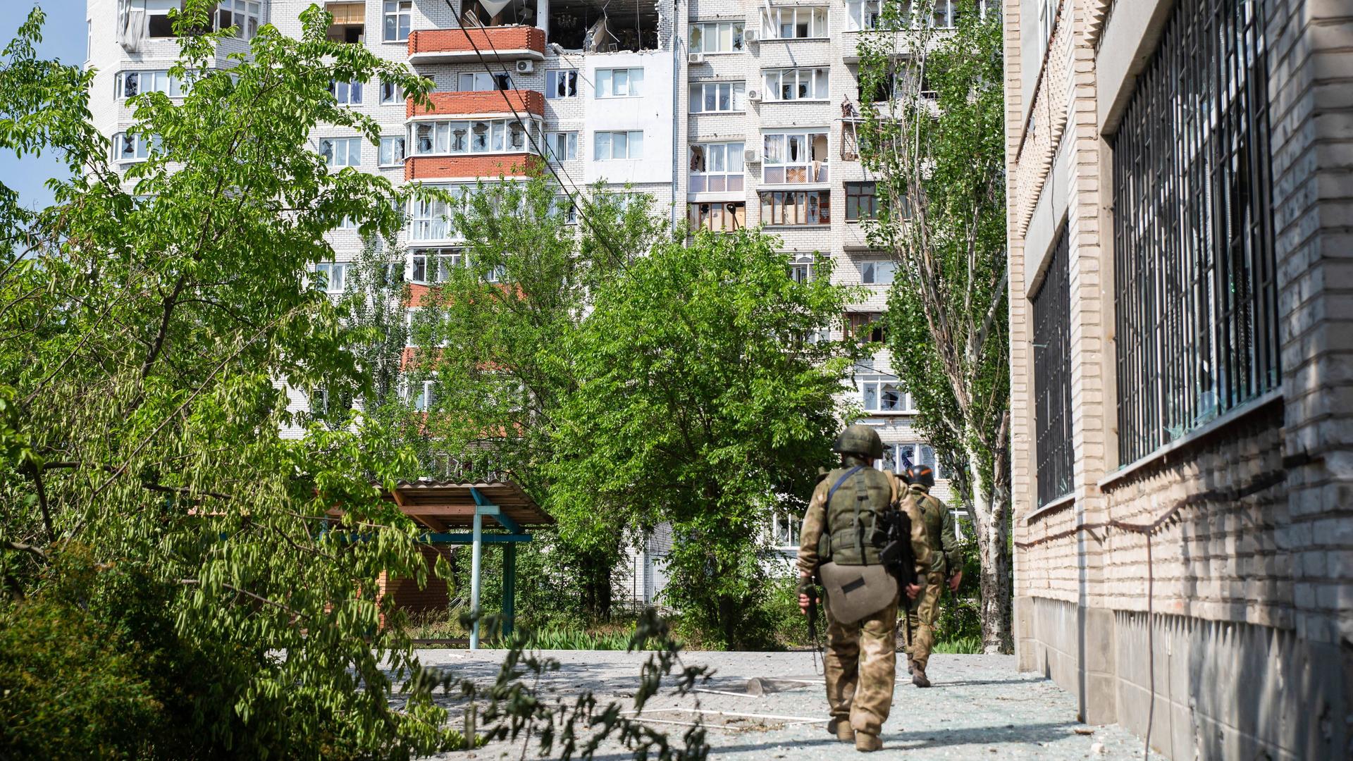 Ein russischer Kämpfer geht durch die ukrainische Stadt Sjewjerodonezk. Ein russischer Kämpfer geht durch die ukrainische Stadt Sjewjerodonezk.
