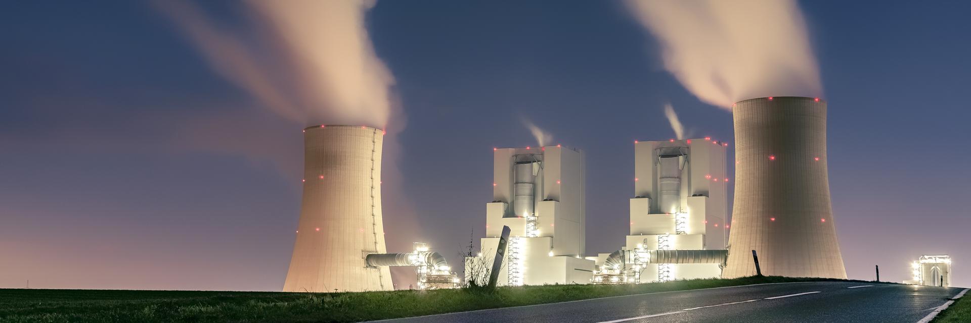 Zu sehen ist ein beleuchtetes Kohlekraftwerk in der Dunkelheit. Zu sehen ist ein beleuchtetes Kohlekraftwerk in der Dunkelheit.