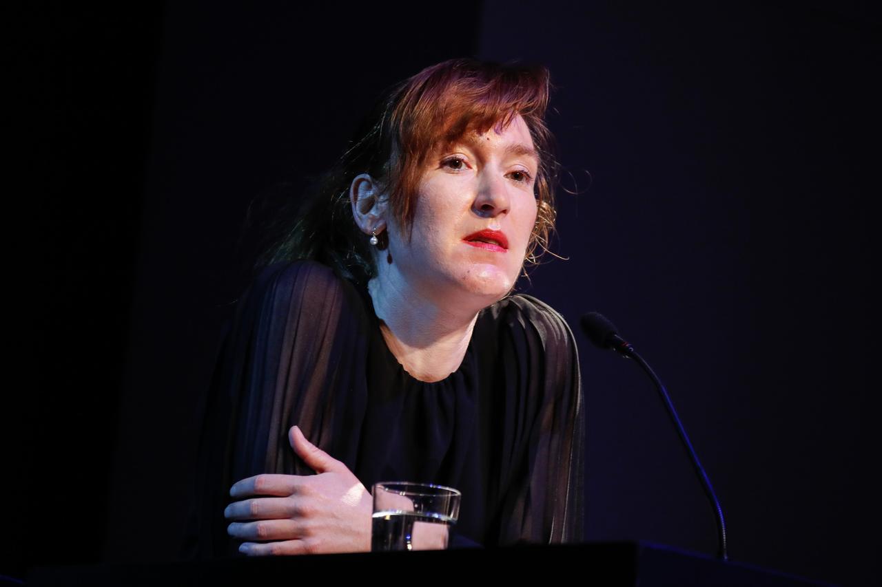 Die Autorin Nora Bossong sitzt in nachdenklicher Pose auf einem Podium. Die Autorin Nora Bossong sitzt in nachdenklicher Pose auf einem Podium.
