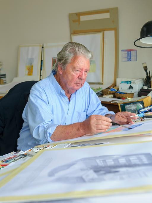 Jean-Jacques Sempé sitzt an einem Schreibtisch und zeichnet