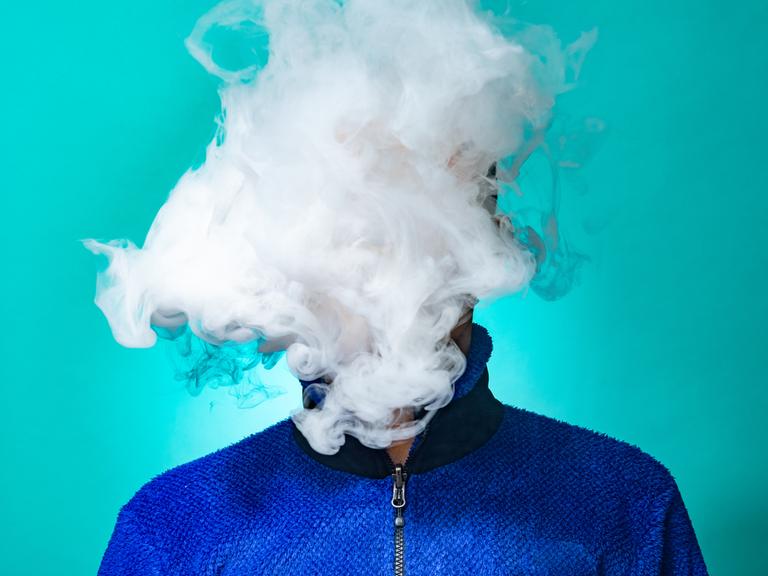 Eine Person hinter einer Wolke von Rauch