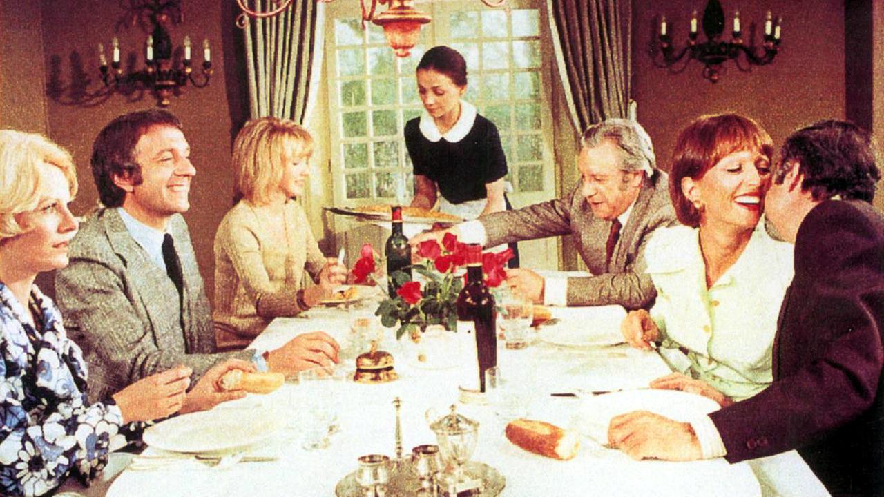 Filmausschnitt aus "Der diskrete Charme der Bourgeoisie" - sechs Personen sitzen am gedeckten Tisch Filmausschnitt aus "Der diskrete Charme der Bourgeoisie" - sechs Personen sitzen am gedeckten Tisch