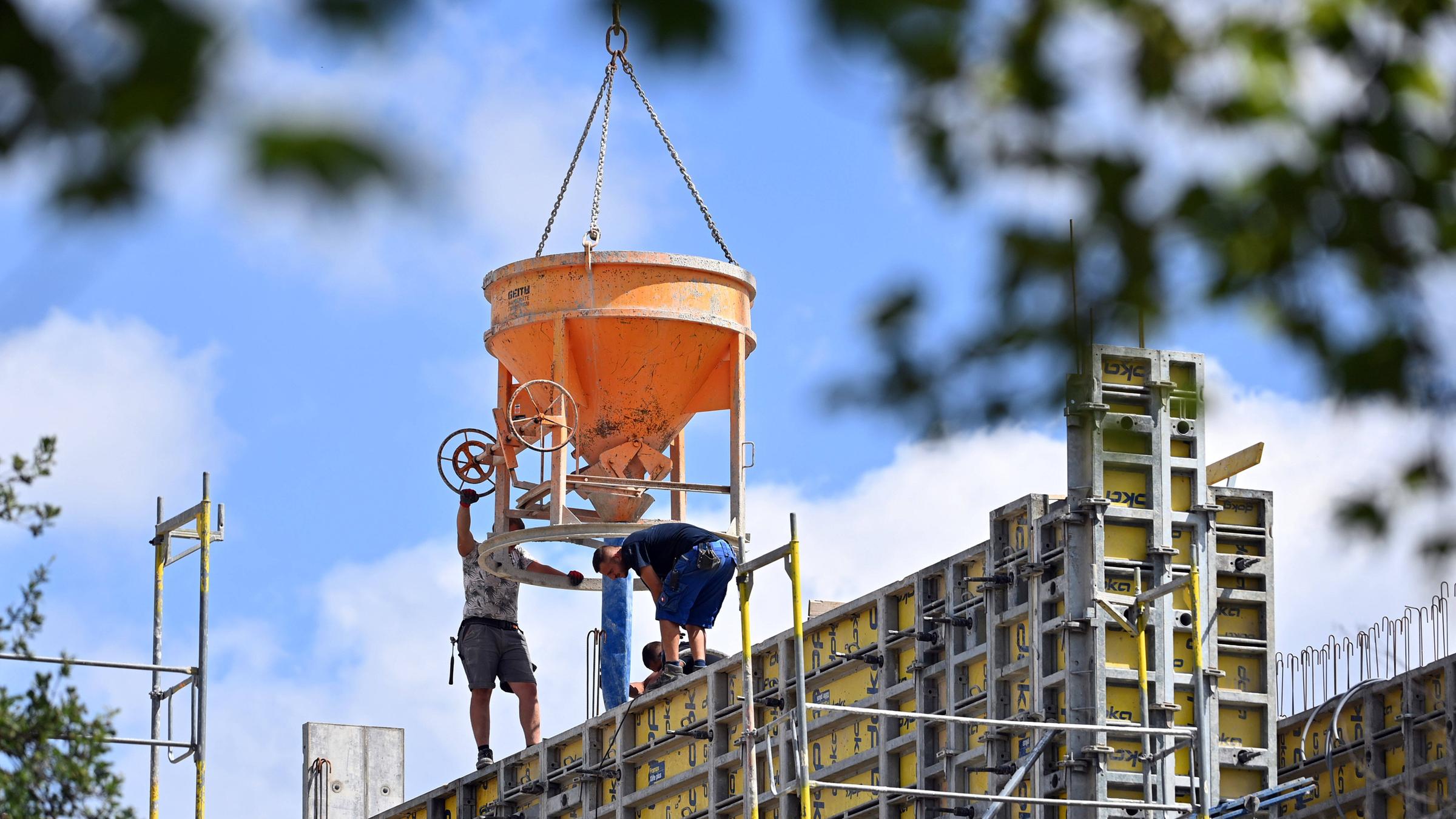 Blick auf Grossbaustelle mit Betonkübeln und zwei nicht erkennbaren Bauarbeitern