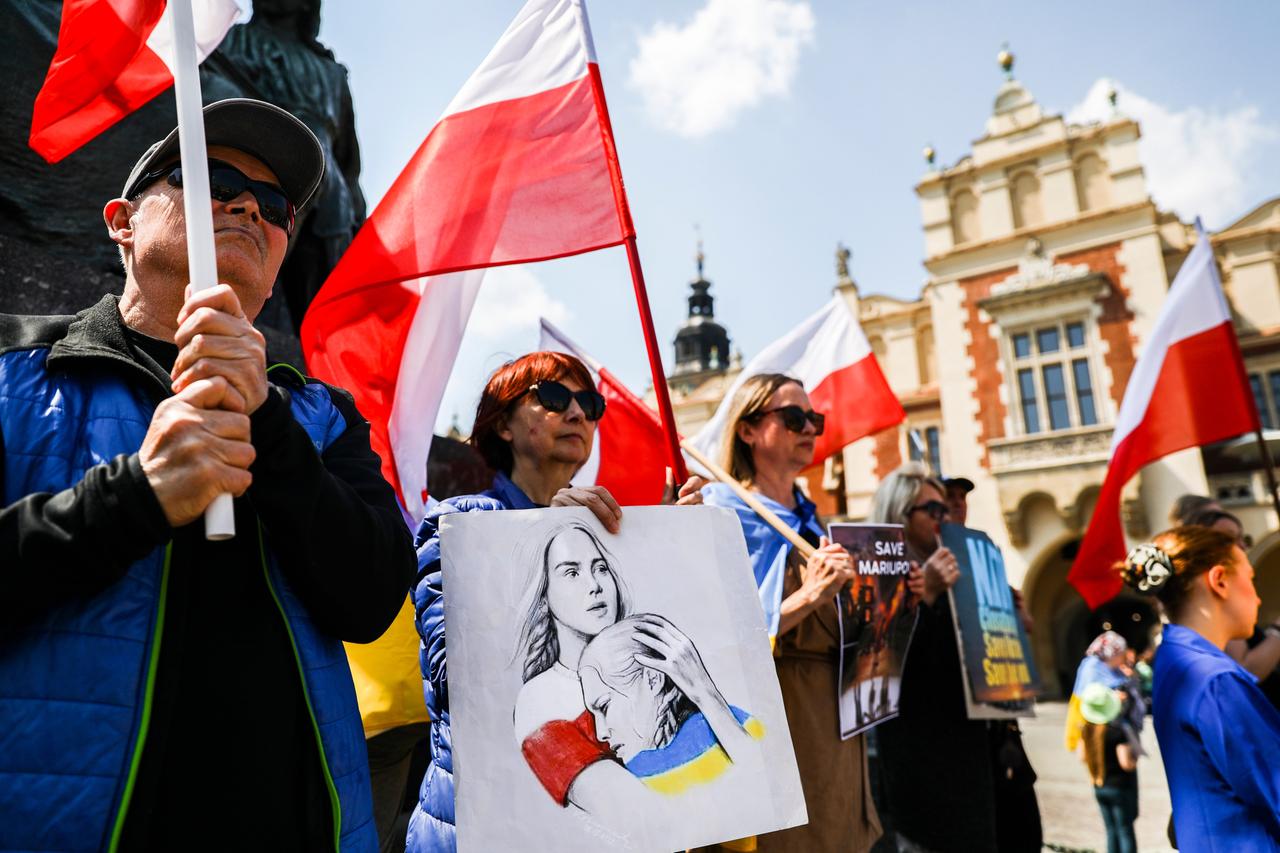 Menschen mit polnischen und ukrainischen Flaggen auf einem Platz in Krakau