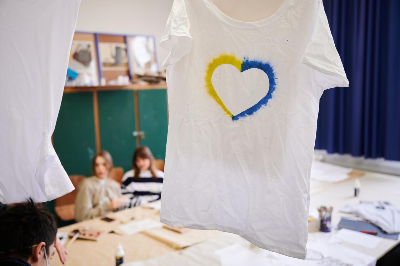 Ein T-Shirt mit einem Herz, umrahmt von den ukrainischen Farben hängt im Klassenraum einer Willkommensklasse am Willy-Graf-Gymnasium in Berlin-Lichterfelde. Ein T-Shirt mit einem Herz, umrahmt von den ukrainischen Farben hängt im Klassenraum einer Willkommensklasse am Willy-Graf-Gymnasium in Berlin-Lichterfelde.