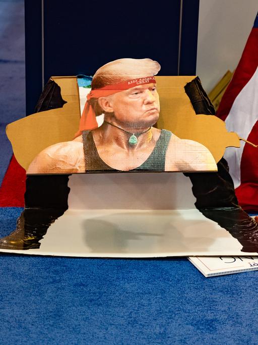 Ein Pappaufsteller während der Konferenz der Konservativen in Dallas im US-Staat Texas. Er zeigt eine Fotomontage des Ex-US-Präsidenten Donald Trump im Rambo-Stil mit rotem Stirnband. 