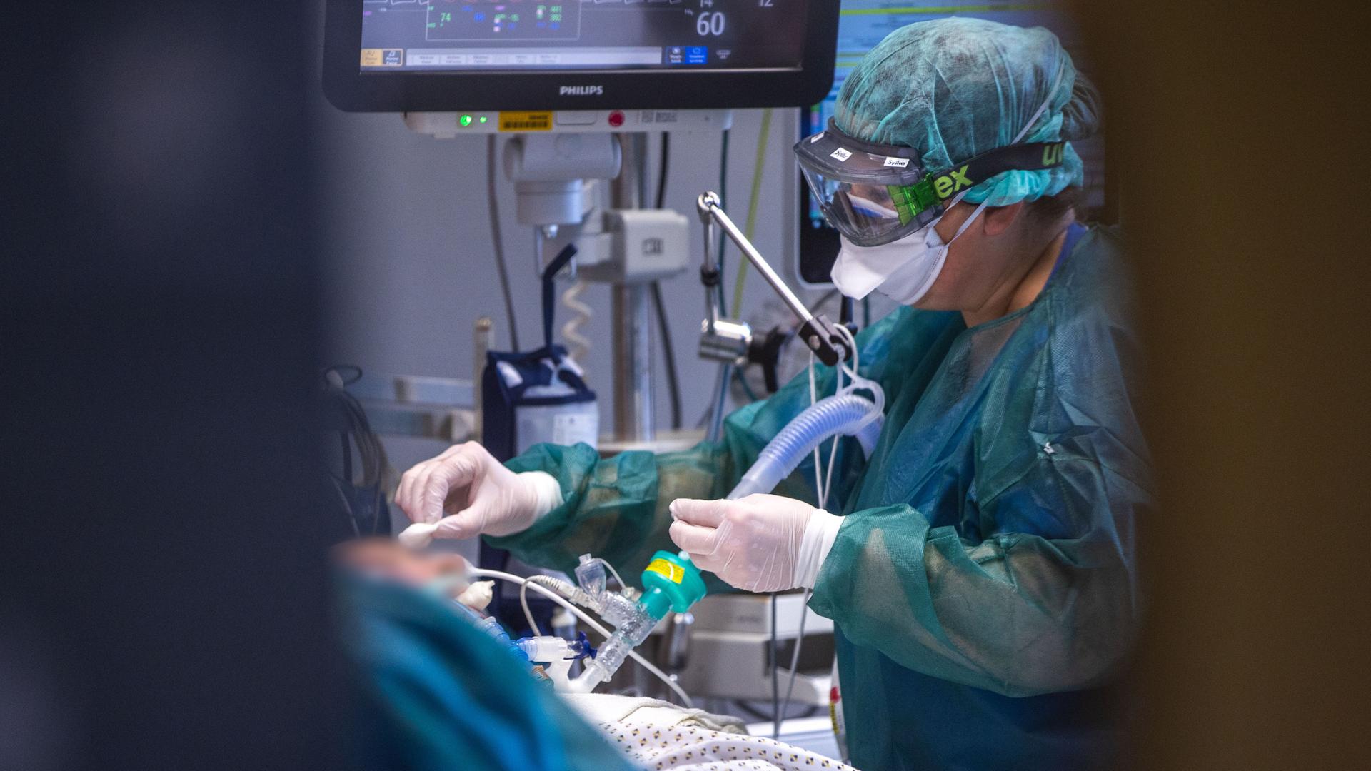 Eine Intensivschwester betreut einen Patienten in einem der Behandlungszimmer der Intensivstation in der Universitätsmedizin Rostock Eine Intensivschwester betreut einen Patienten in einem der Behandlungszimmer der Intensivstation in der Universitätsmedizin Rostock