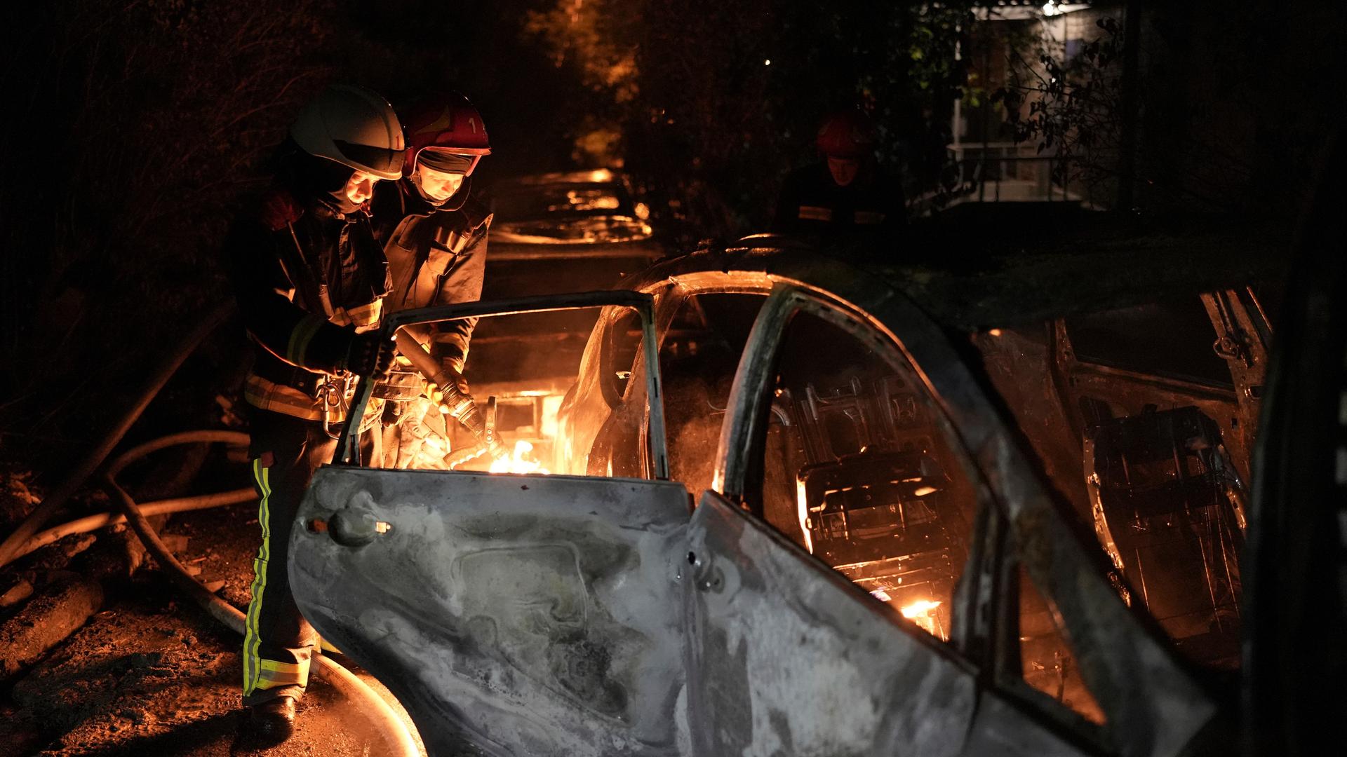Zu sehen sind Rettungskräfte in Kiew, die nach einem Luftangriff ein brennendes Fahrzeug löschen.