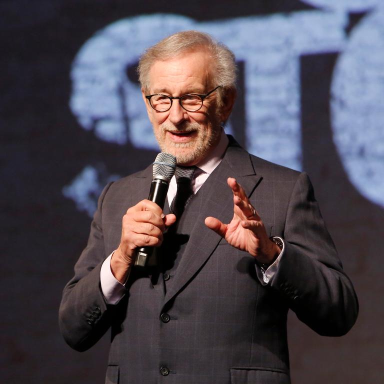 Steven Spielberg hält auf einer Bühne ein Mikrofon in der Hand. Im Hintergrund ist ein Teil des Schriftzugs "West Side Story" zu erkenenn. Steven Spielberg hält auf einer Bühne ein Mikrofon in der Hand. Im Hintergrund ist ein Teil des Schriftzugs "West Side Story" zu erkenenn.