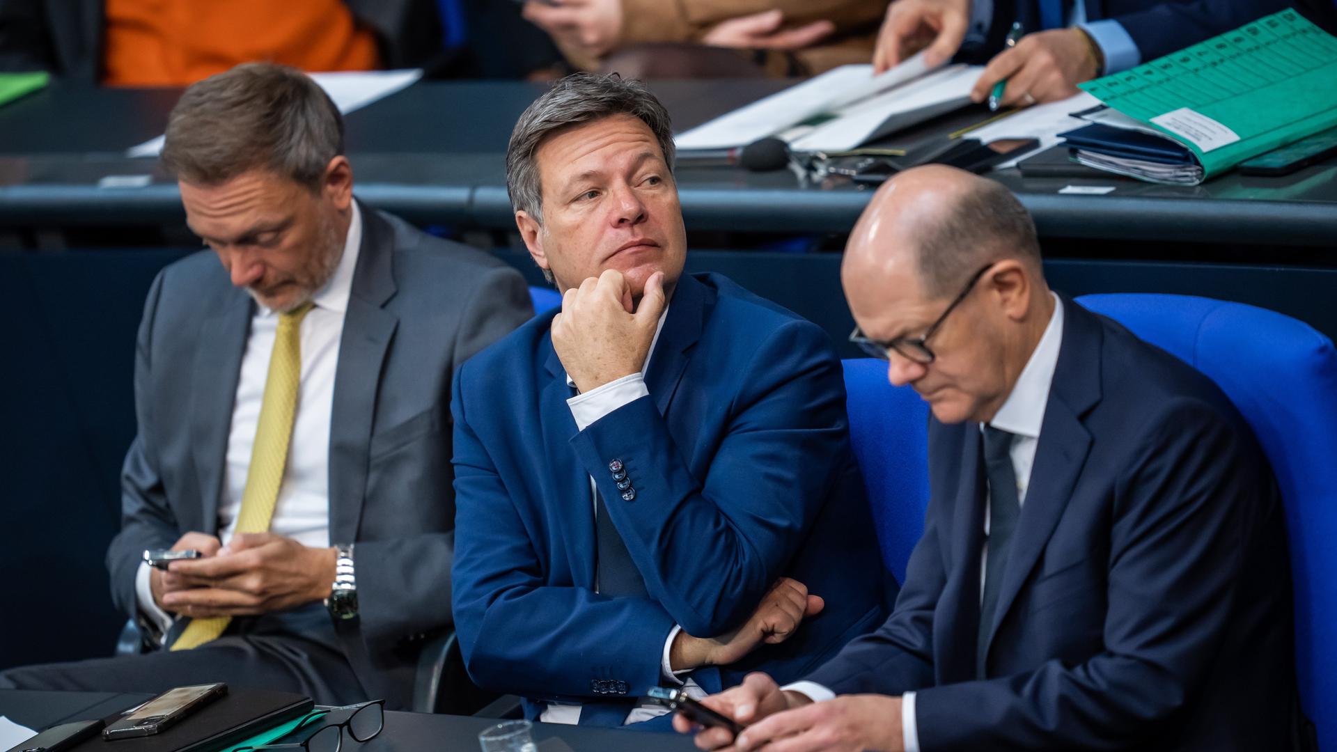 Christian Lindner (FDP), Bundesminister der Finanzen, (l-r) sitzt neben Robert Habeck (Bündnis 90/Die Grünen), Bundesminister für Wirtschaft und Klimaschutz, und Bundeskanzler Olaf Scholz (SPD) auf der Regierungsbank im Bundestag.
