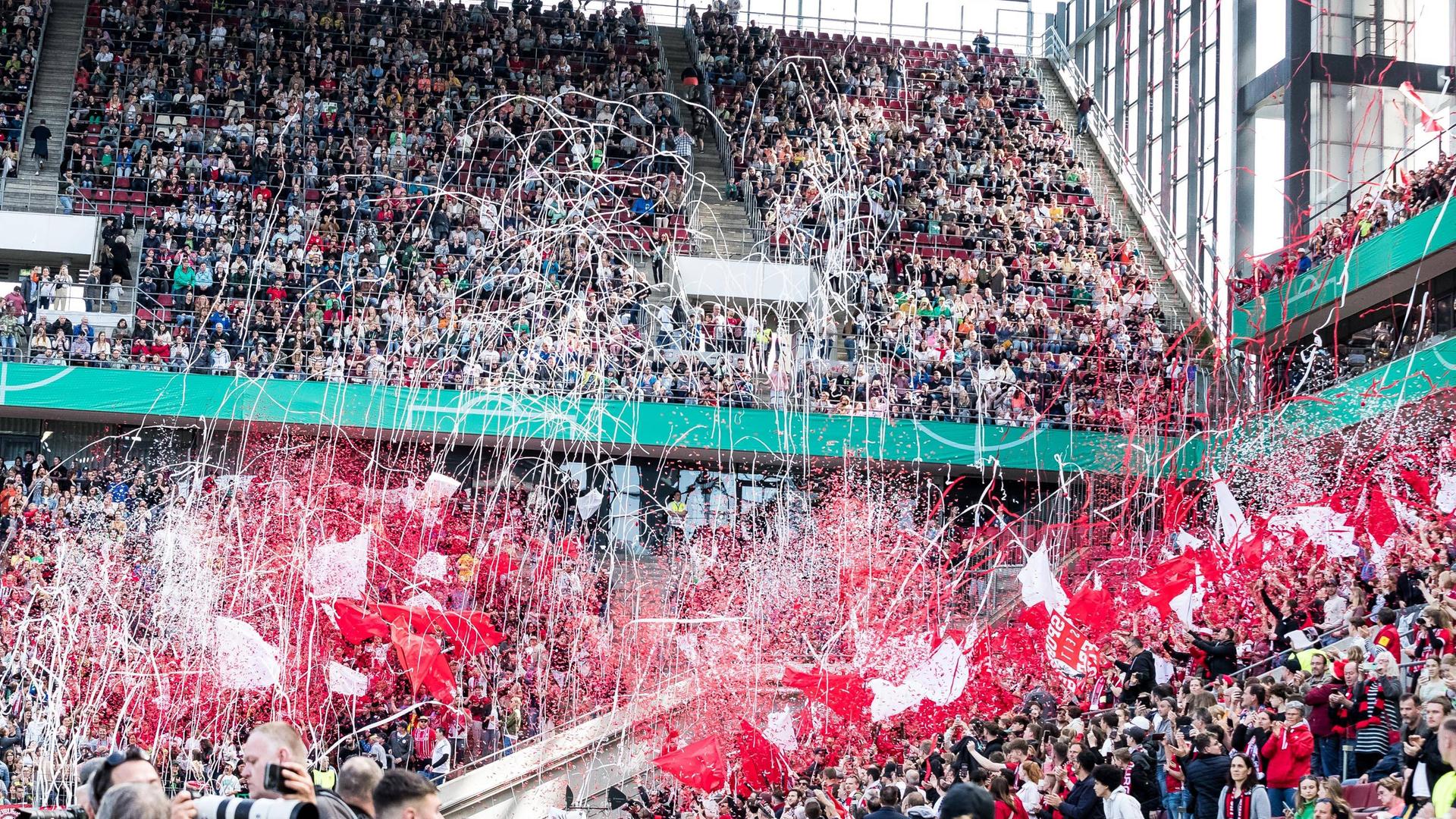 Die Fans des SC Freiburg lassen zu Beginn des Pakalfinals in Köln Konfetti fliegen und wedeln mit Fahnen. Die Fans des SC Freiburg lassen zu Beginn des Pakalfinals in Köln Konfetti fliegen und wedeln mit Fahnen.