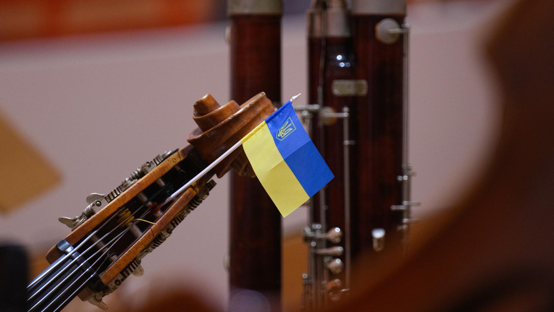 Eine kleine ukrainische Fahne steckt am Ende eines Kontrabasses, der auf der Bühne angelehnt ist. Eine kleine ukrainische Fahne steckt am Ende eines Kontrabasses, der auf der Bühne angelehnt ist.