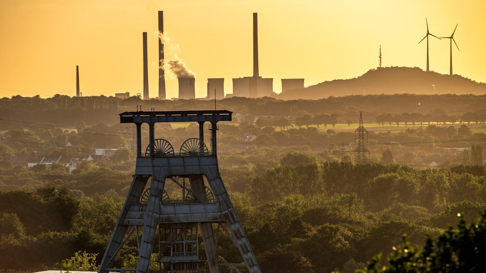 Steinkohlekraftwerk Scholven, Gelsenkirchen,hinten, vorne das Doppelbock Fördergerüst des stillgelegten Bergwerks Ewald in Herten, am Horizont sind Windräder zu sehen. Steinkohlekraftwerk Scholven, Gelsenkirchen,hinten, vorne das Doppelbock Fördergerüst des stillgelegten Bergwerks Ewald in Herten, am Horizont sind Windräder zu sehen.