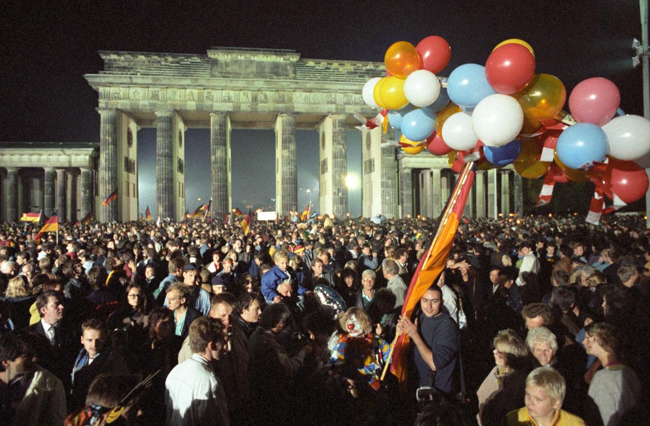 Ausgelassen feiert eine riesige Menschenmenge in der Nacht vom 2. auf den 3. Oktober 1990 vor dem Brandenburger Tor in Berlin die deutsche Wiedervereinigung. Ausgelassen feiert eine riesige Menschenmenge in der Nacht vom 2. auf den 3. Oktober 1990 vor dem Brandenburger Tor in Berlin die deutsche Wiedervereinigung.