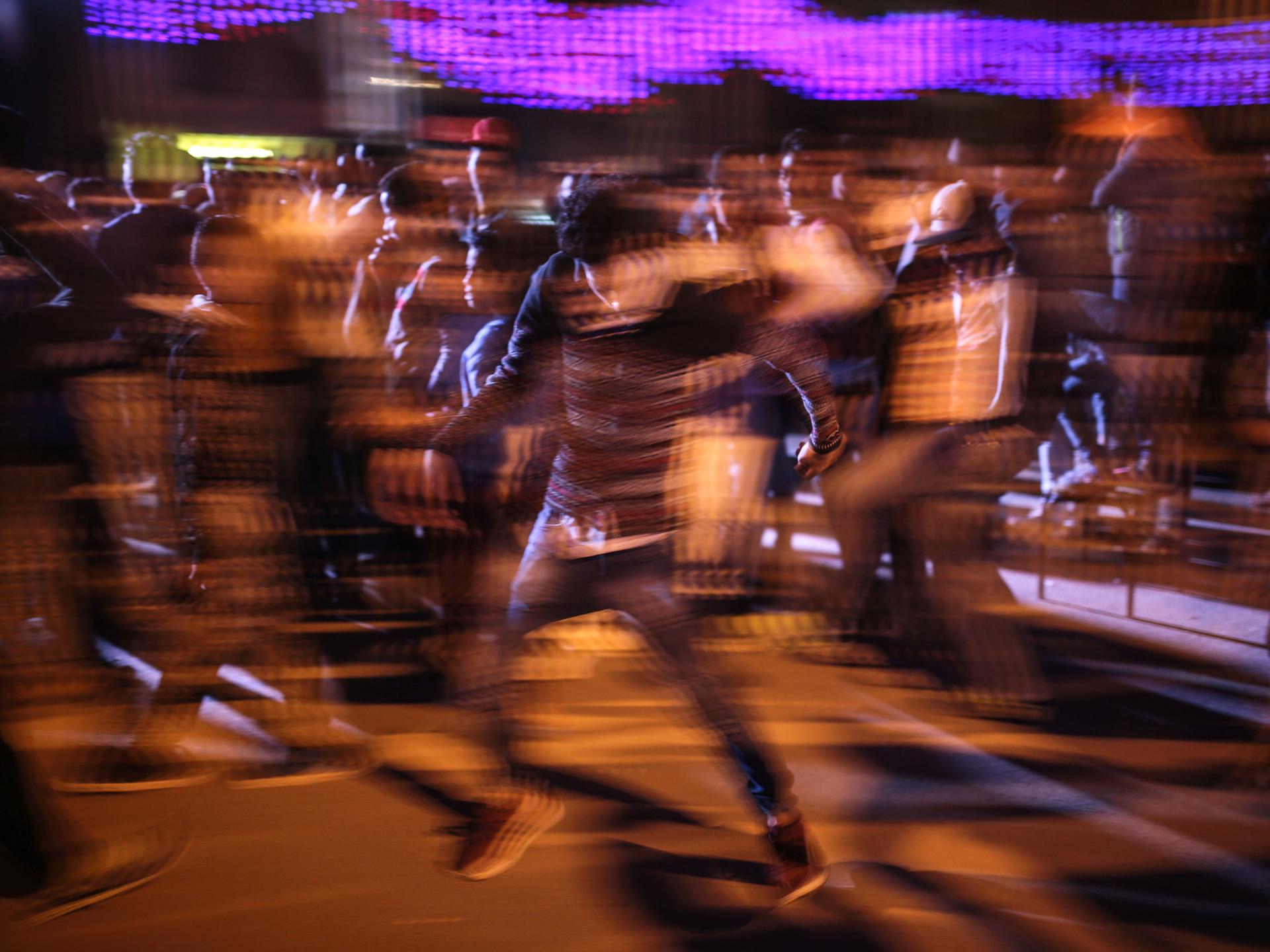 Ein Mann tanzt in einer Gruppe nach Musik. Durch die Langzeitaufnahme kann man die Bewegungen der Tänzer erahnen. Ein Mann tanzt in einer Gruppe nach Musik. Durch die Langzeitaufnahme kann man die Bewegungen der Tänzer erahnen.