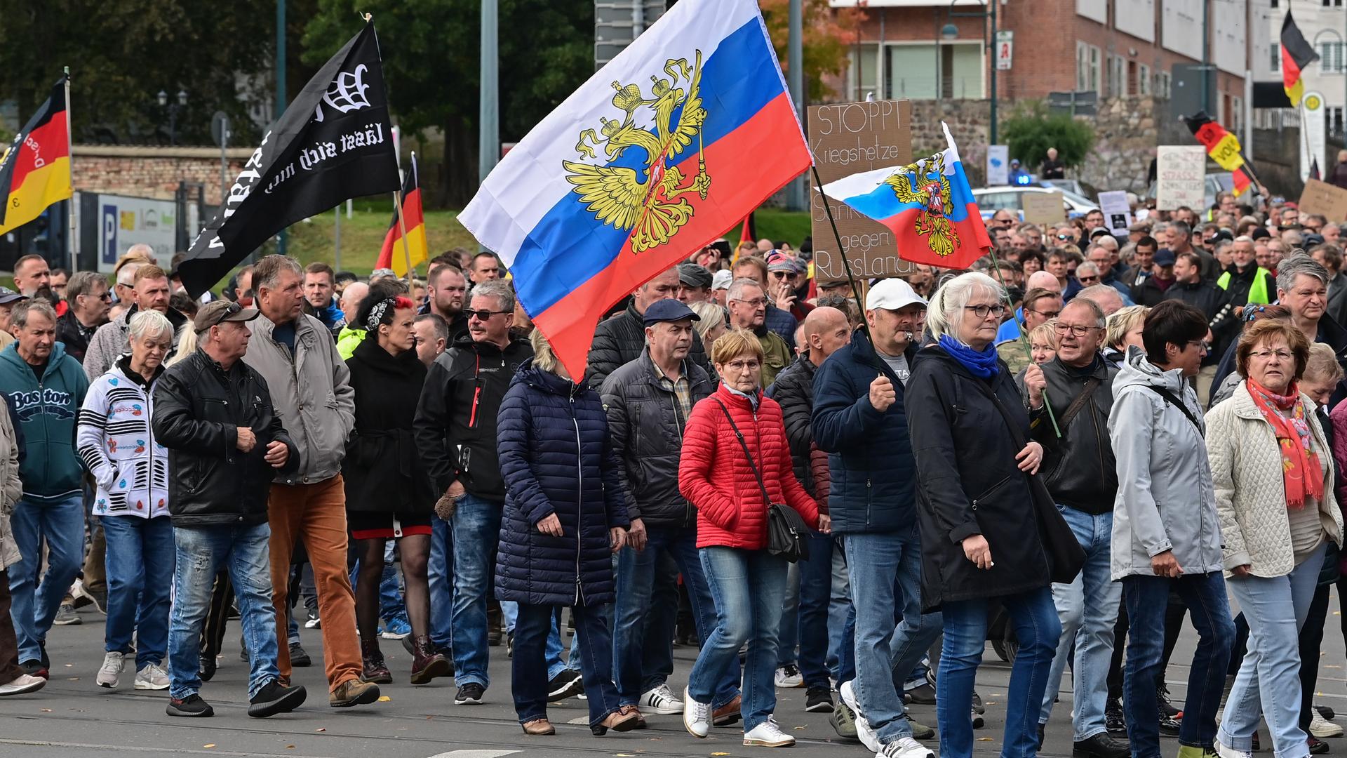 Viele Menschen nehmen an einer Protest-Demonstration im Stadtzentrum teil und schwenken dabei unter anderem auch Russland-Fahnen. Erneut sind an diesem Montag in Frankfurt (Oder) Hunderte Menschen zu einer Protest-Demonstration auf die StraÃe gegangen. Anlass waren die Energiekrise, der Ukraine-Krieg und die Corona-Politik. Mit Trommeln, Trillerpfeifen, Deutschland-Fahnen und russischen Flaggen zogen sie am Tag der Deutschen Einheit durch die Innenstadt, wie ein dpa-Reporter berichtete. Er schätzte die Teilnehmerzahl auf etwa 2000. Auf Transparenten stand unter anderem Â«Nur Frieden ist ein SiegÂ» oder waren Friedenstauben abgebildet.